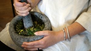 grinding herbs in a pestle and mortar